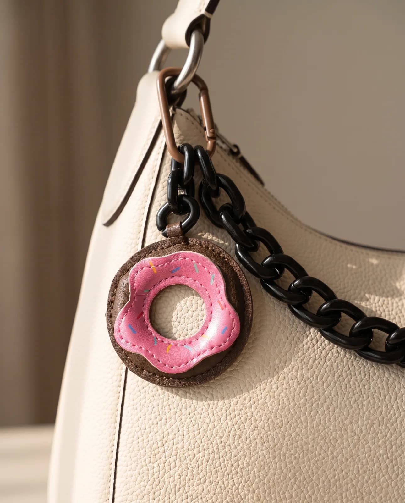 Doughnut leather charm on a cream leather handbag