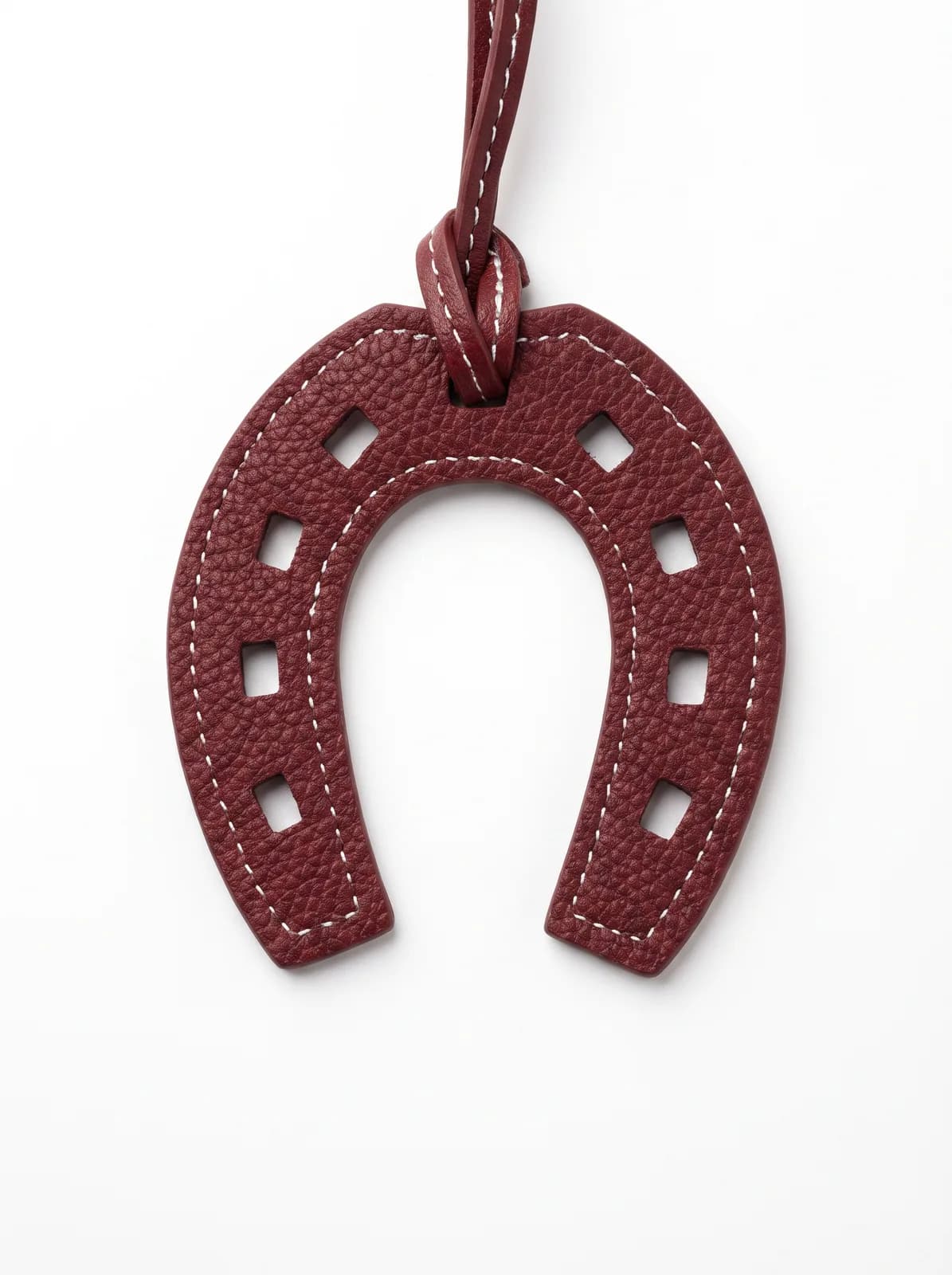 Burgundy leather horseshoe charm on a white background
