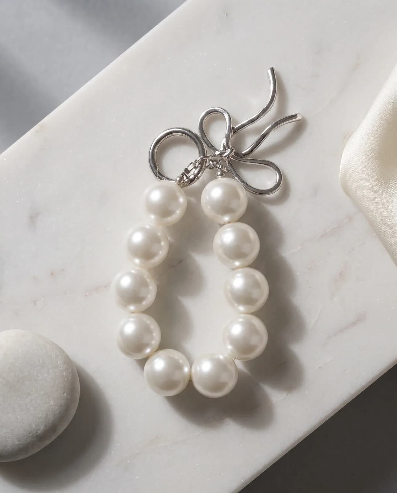 Pearl loop charm on pale marble