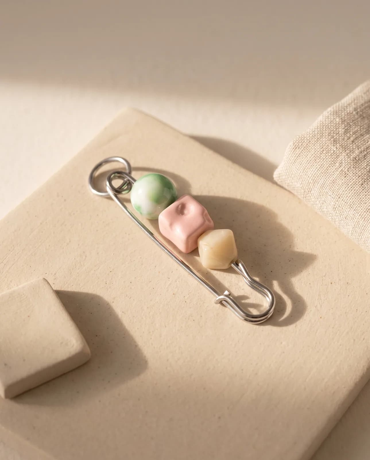 Pastel ceramic bead pin on sand stoneware