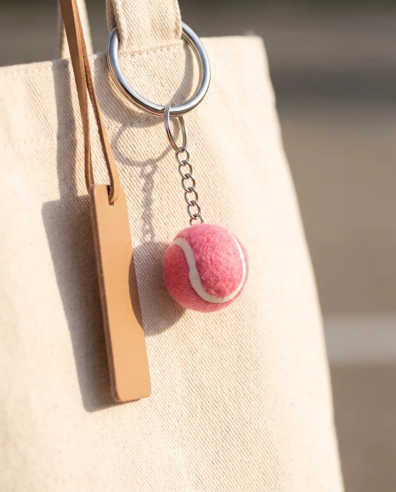 Pink tennis ball keyring on a canvas sports tote