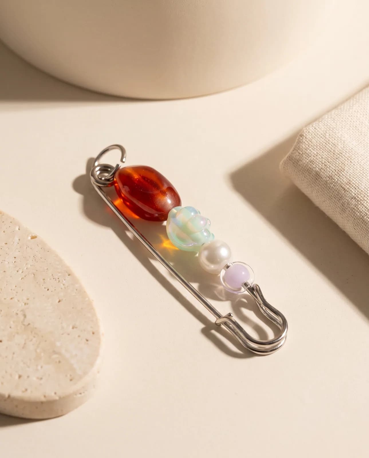 Ruby and pearl bead pin on cream plaster in hard light