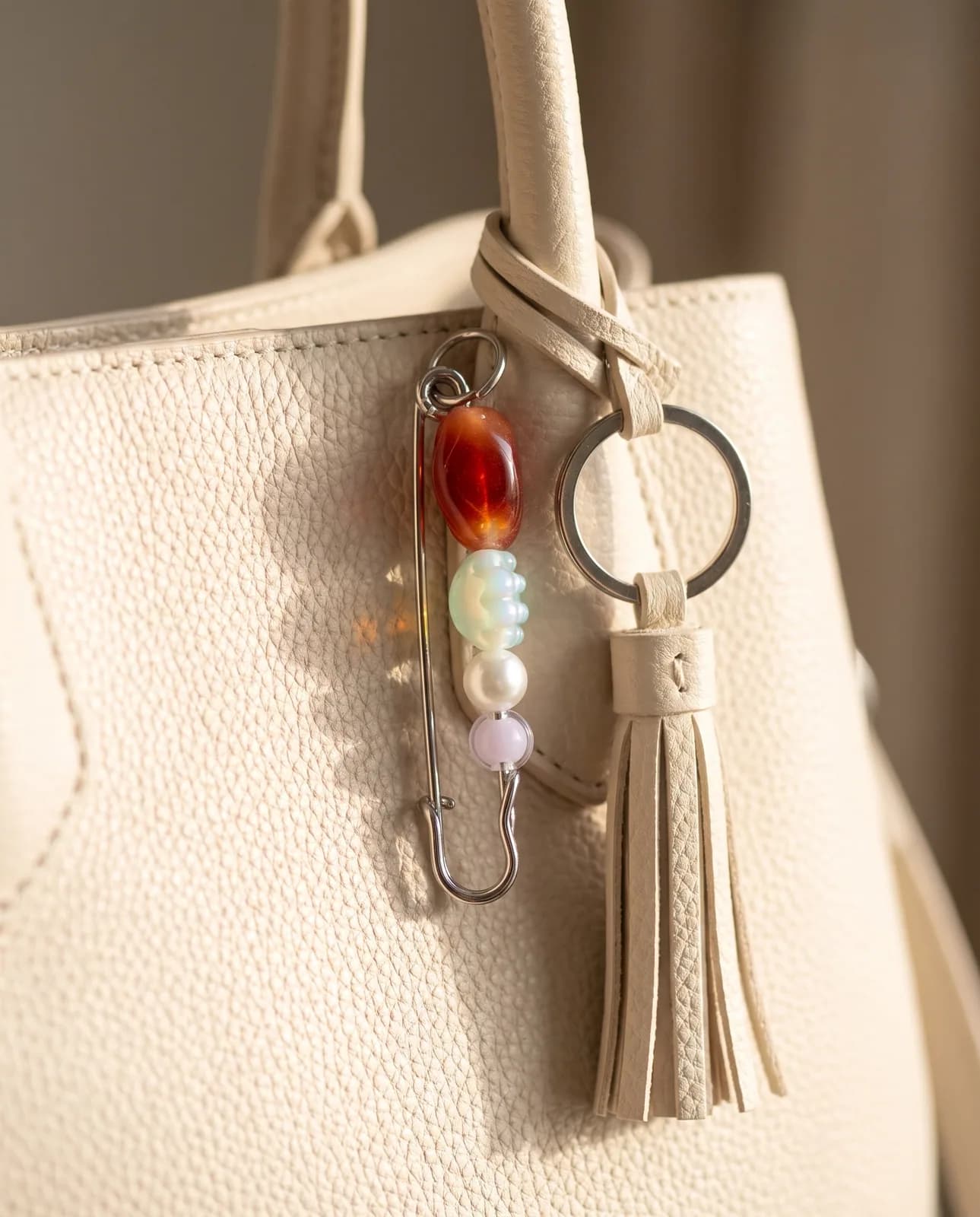 Ruby and pearl bead pin on a cream leather handbag