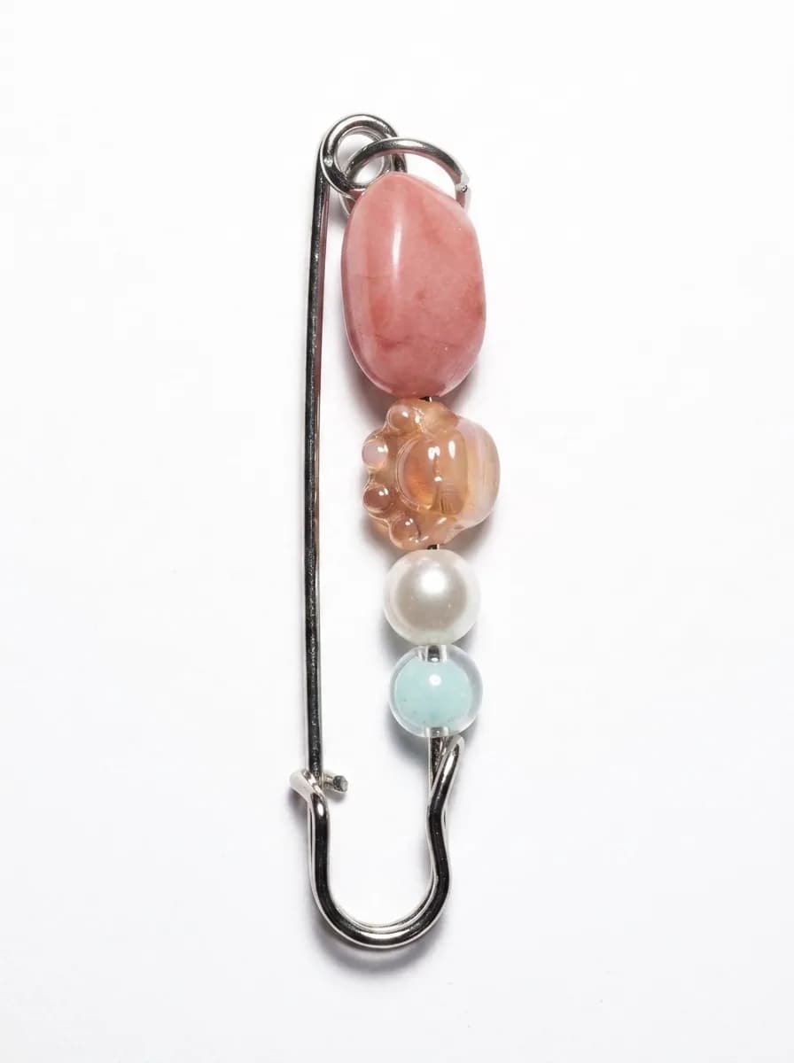 Rose quartz kilt pin on a white background