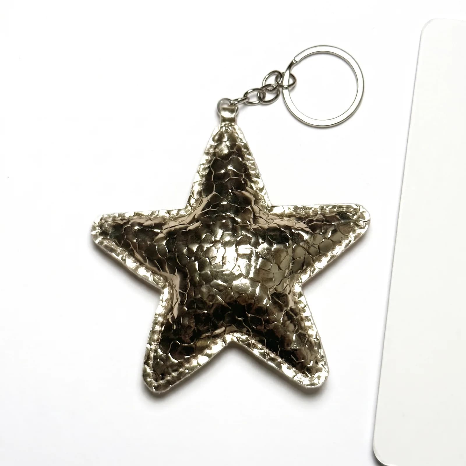 Metallic gold star keyring on a white background