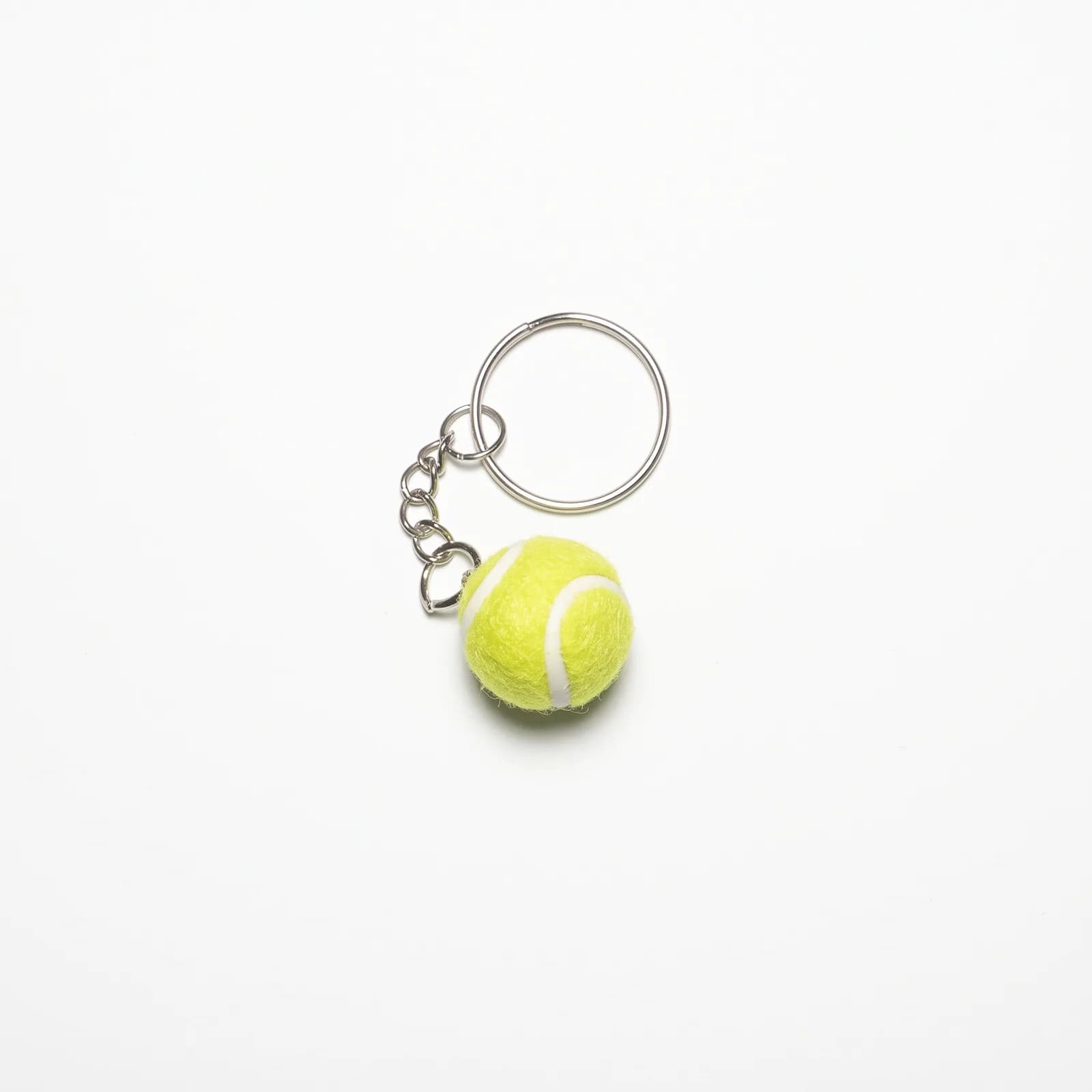 Yellow tennis ball keyring on a white background